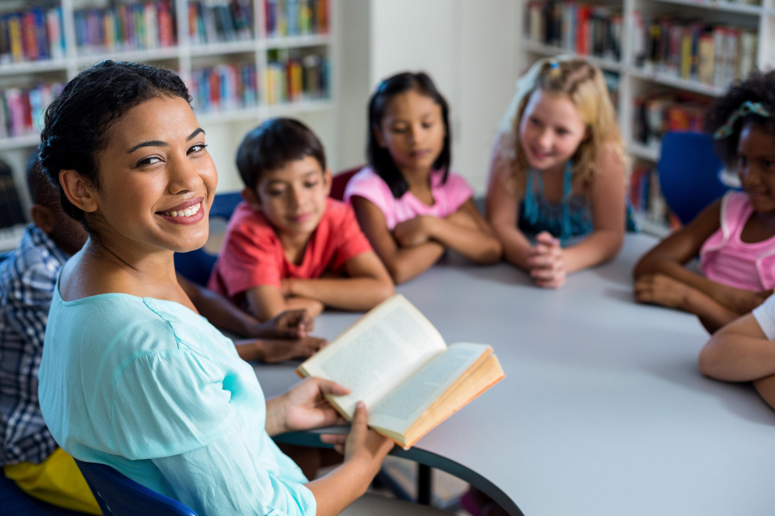 Pupils listening to their teacher reading in the library